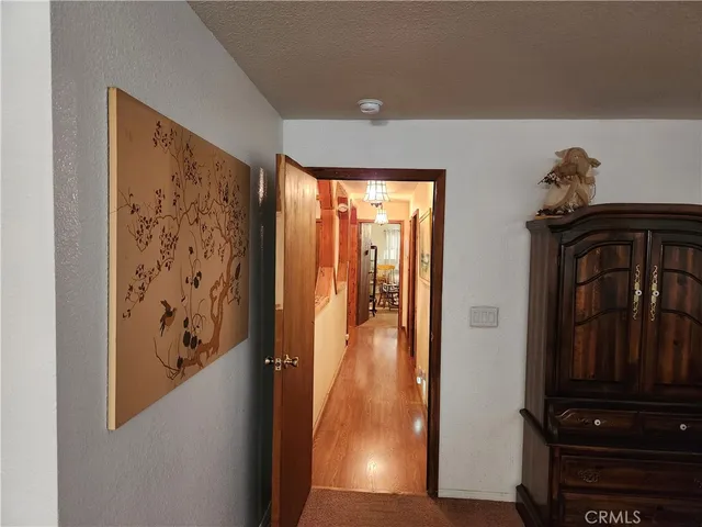 a view of a livingroom with furniture a flat screen tv wooden floor and staircase