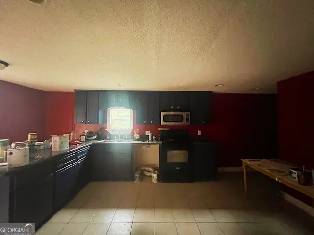 a kitchen with a sink a stove and cabinets