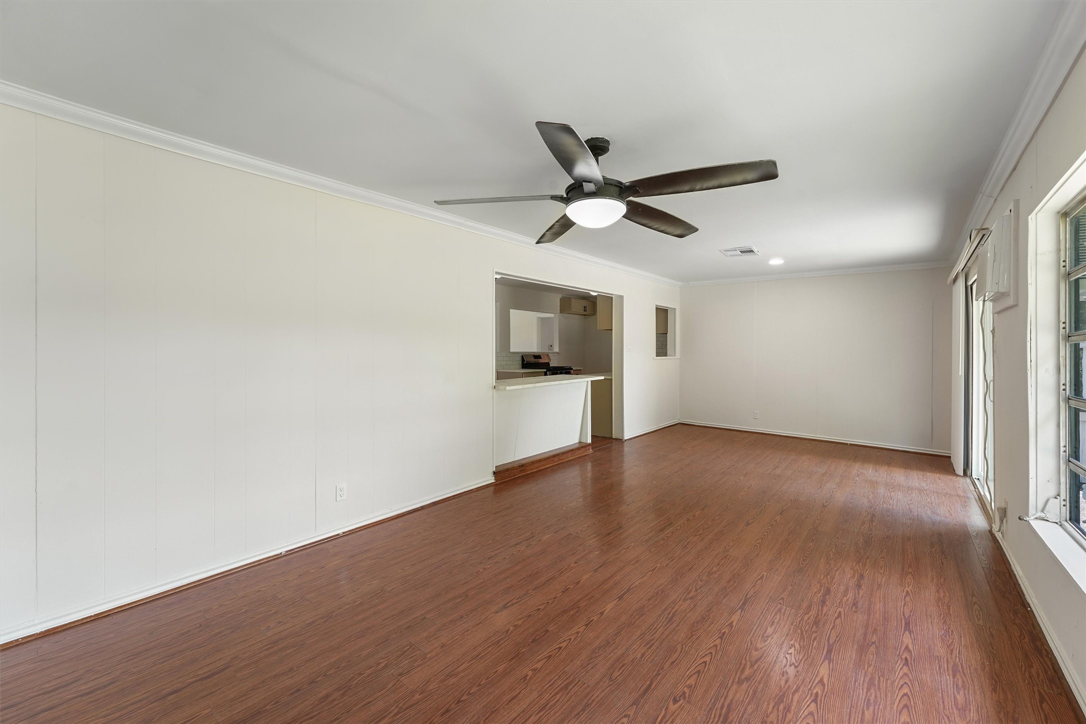5826 Belmark Street Houston, TX 77033 - Photo 3 of 15 an empty room with wooden floor and a ceiling fan