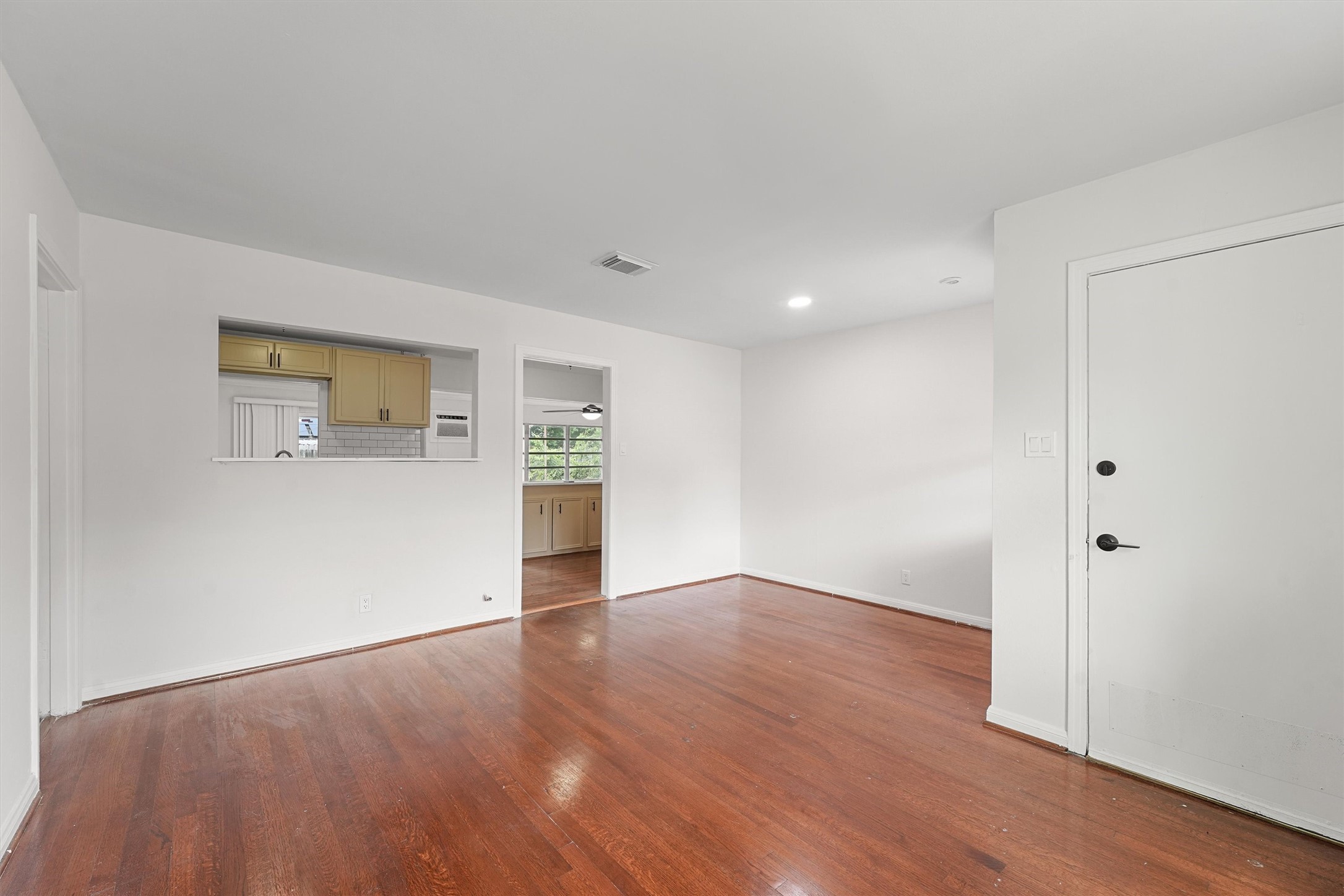 5826 Belmark Street Houston, TX 77033 - Photo 8 of 15 a view of an empty room with wooden floor and a window