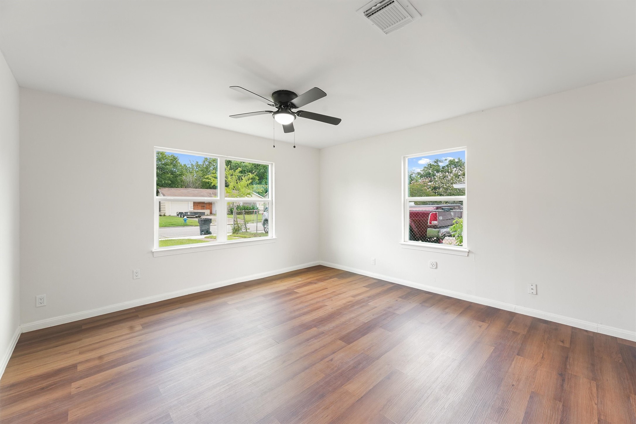 5826 Belmark Street Houston, TX 77033 - Photo 9 of 15 a view of an empty room with a window and wooden floor