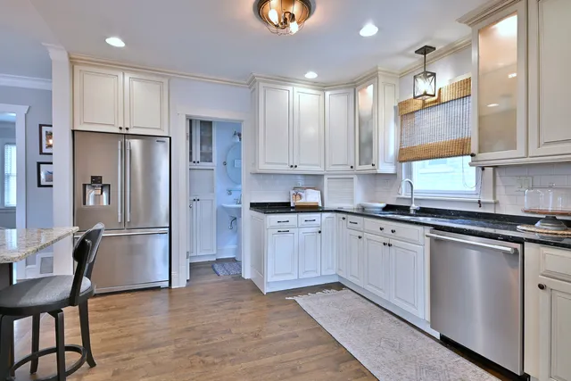 a kitchen with stainless steel appliances granite countertop a refrigerator and a stove top oven