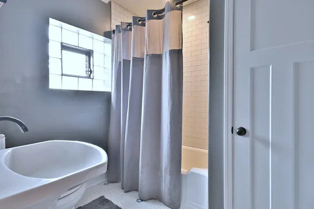 a bathroom with a white tub a shower and a sink