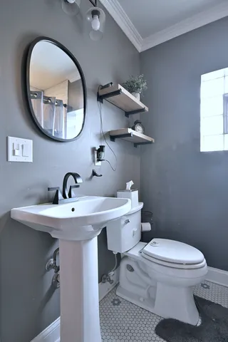 a bathroom with a toilet a sink and a mirror