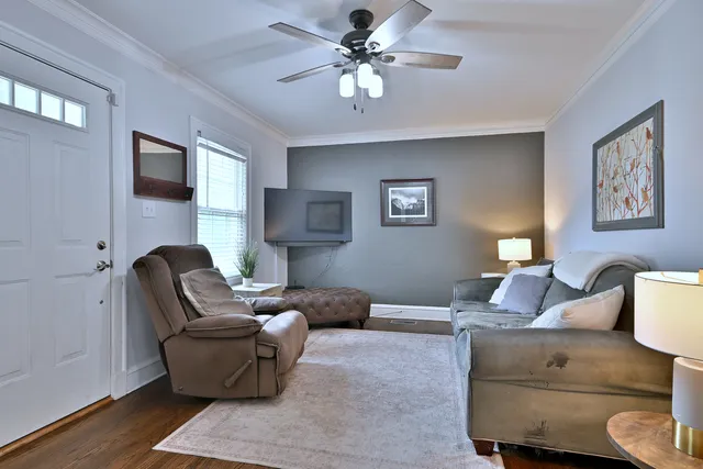 a living room with furniture and a ceiling fan