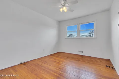 a view of empty room with wooden floor