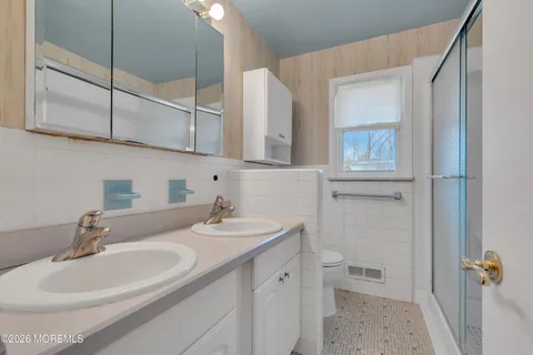 a bathroom with a sink a toilet and a mirror