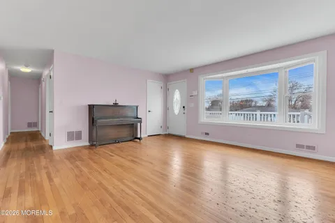 a view of an empty room with a fireplace and a window