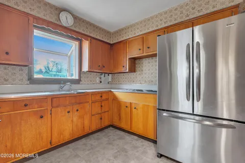a kitchen with stainless steel appliances granite countertop a refrigerator a sink and white cabinets