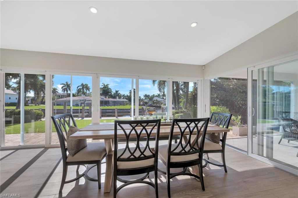 1925 Tarpon Road Naples, FL 34102 - Photo 12 of 41 a view of a dining room with furniture large windows and wooden floor