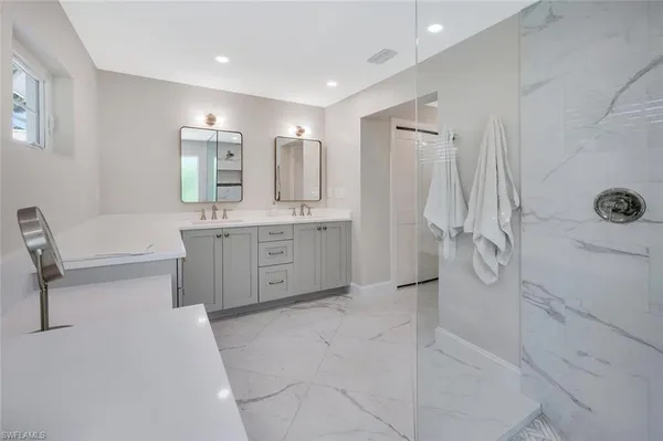 a spacious bathroom with a tub sink and mirror