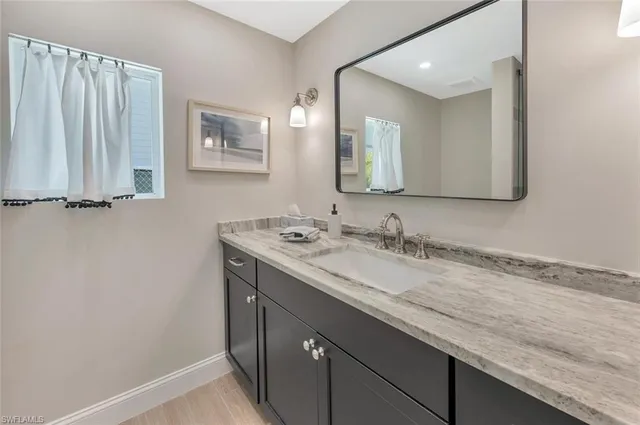 a bathroom with a granite countertop sink and a mirror