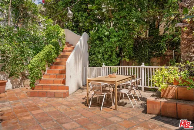 a living room with furniture potted plant and a large window