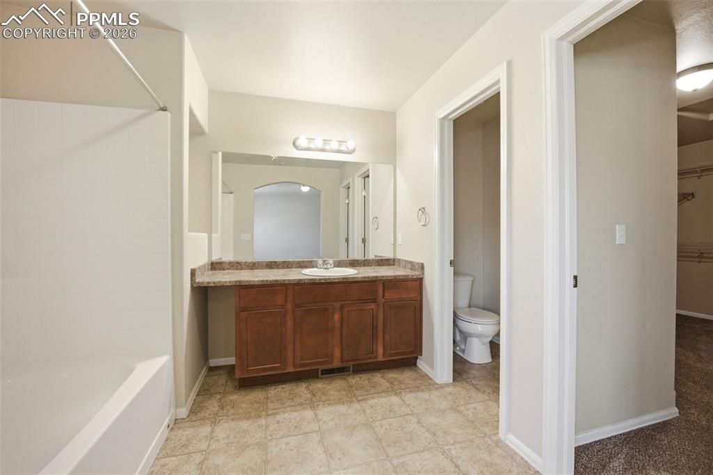 3019 Shikra View Colorado Springs, CO 80916 - Photo 17 of 42 a spacious bathroom with a granite countertop sink mirror and a bathtub