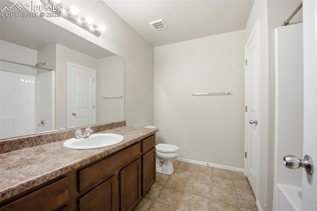 3019 Shikra View Colorado Springs, CO 80916 - Photo 24 of 42 a bathroom with a granite countertop sink a toilet and a mirror