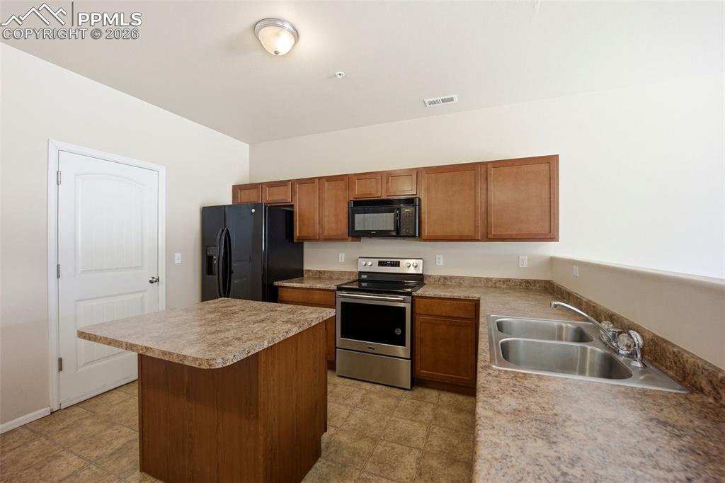3019 Shikra View Colorado Springs, CO 80916 - Photo 7 of 42 a kitchen with stainless steel appliances granite countertop a sink stove and refrigerator