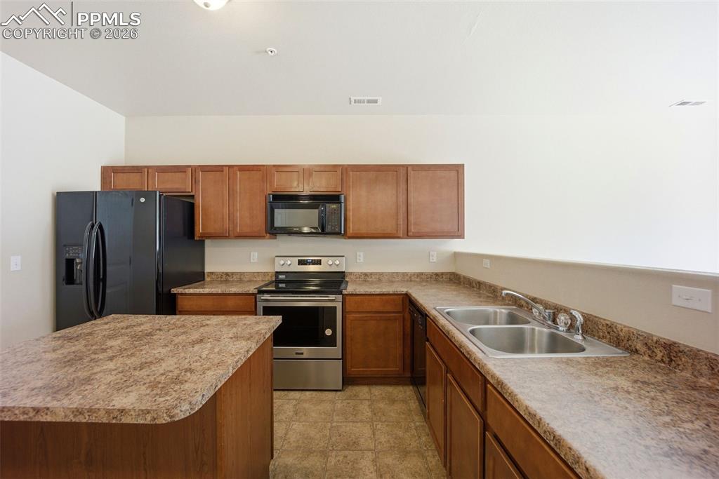 3019 Shikra View Colorado Springs, CO 80916 - Photo 8 of 42 a kitchen with stainless steel appliances granite countertop a sink stove microwave and refrigerator