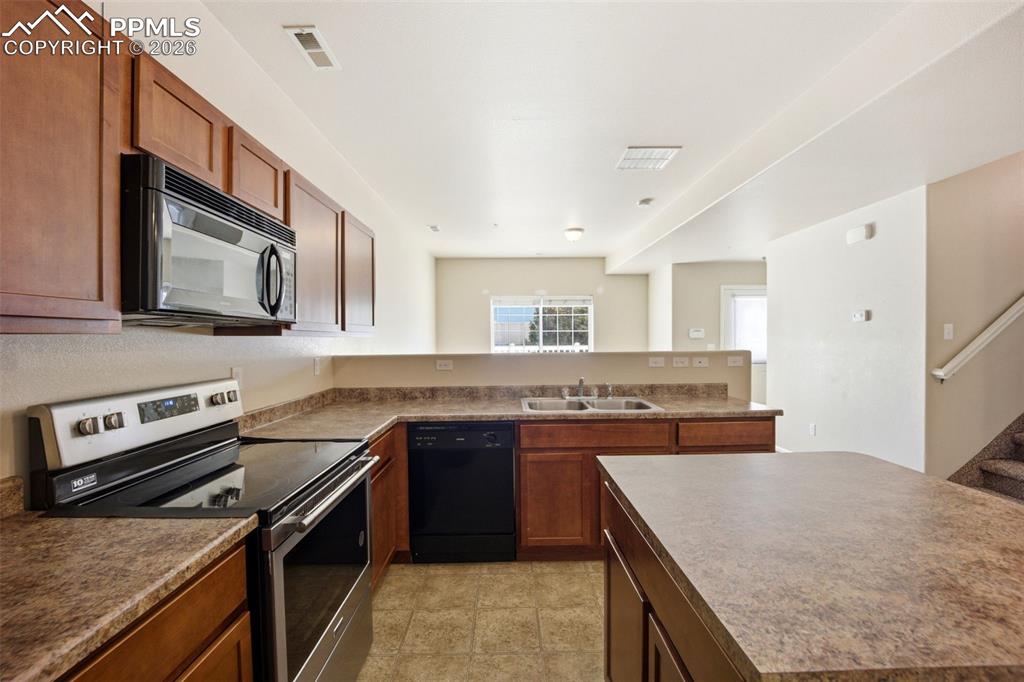 3019 Shikra View Colorado Springs, CO 80916 - Photo 10 of 42 a kitchen with stainless steel appliances granite countertop a stove and a sink