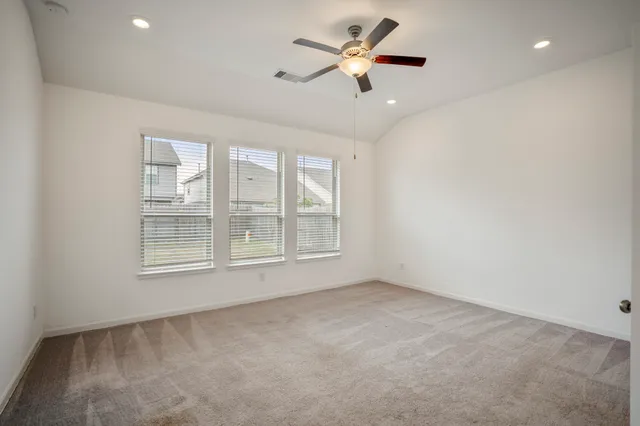 an empty room with closet and a ceiling fan