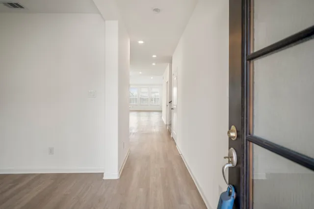 a view of a hallway with wooden floor