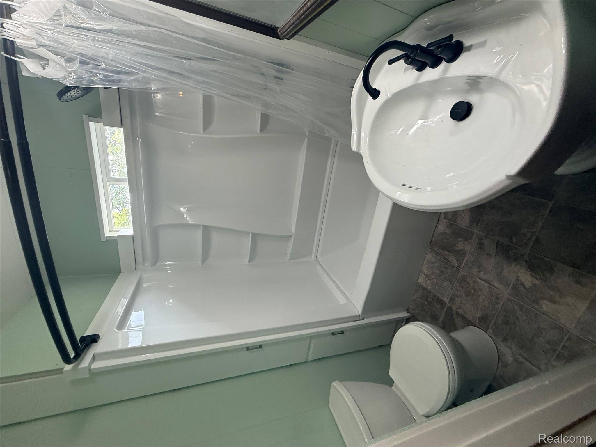 3176 East Fisher Road Bay City, MI 48706 - Photo 12 of 25 Bathroom featuring shower / bath combo with shower curtain and toilet