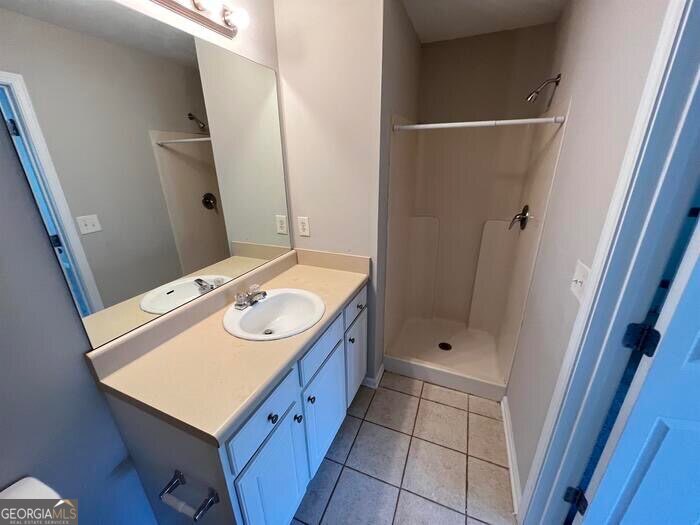 879 Langston Trace Stone Mountain, GA 30083 - Photo 13 of 16 a bathroom with a sink a toilet a mirror and shower