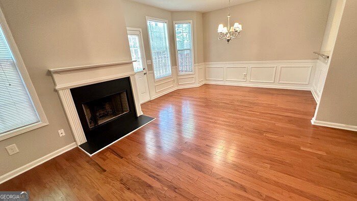 879 Langston Trace Stone Mountain, GA 30083 - Photo 2 of 16 an empty room with wooden floor fireplace and windows