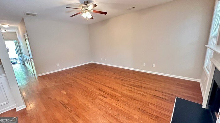 879 Langston Trace Stone Mountain, GA 30083 - Photo 3 of 16 an empty room with wooden floor fan and windows
