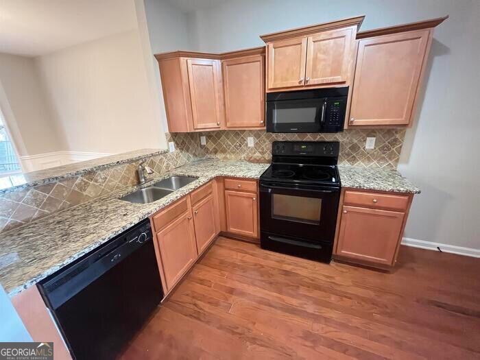 879 Langston Trace Stone Mountain, GA 30083 - Photo 8 of 16 a kitchen with stainless steel appliances granite countertop a stove top oven microwave and sink