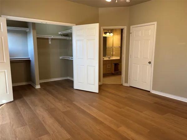 an empty room with wooden floor and closet