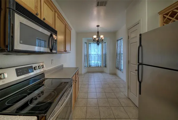 a kitchen with a refrigerator and a stove top oven