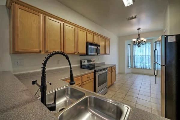 a kitchen with stainless steel appliances granite countertop a refrigerator and a stove top oven