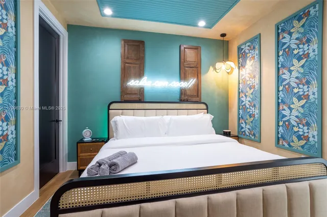 a bedroom with a large bed and a chandelier