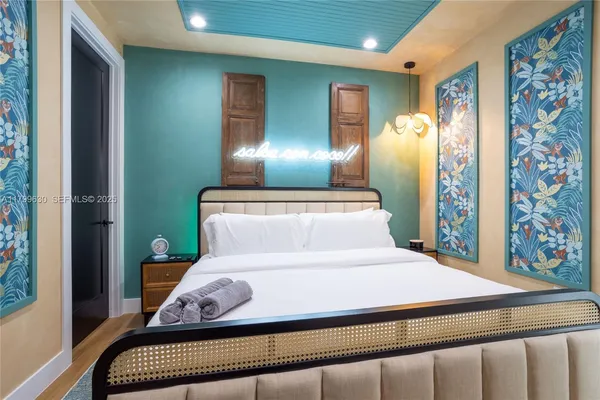 a bedroom with a large bed and a chandelier