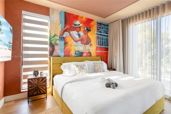 a bedroom with a bed and a painting on the wall