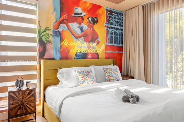 a bedroom with a bed and a painting on the wall