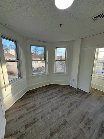 a view of an empty room window and wooden floor