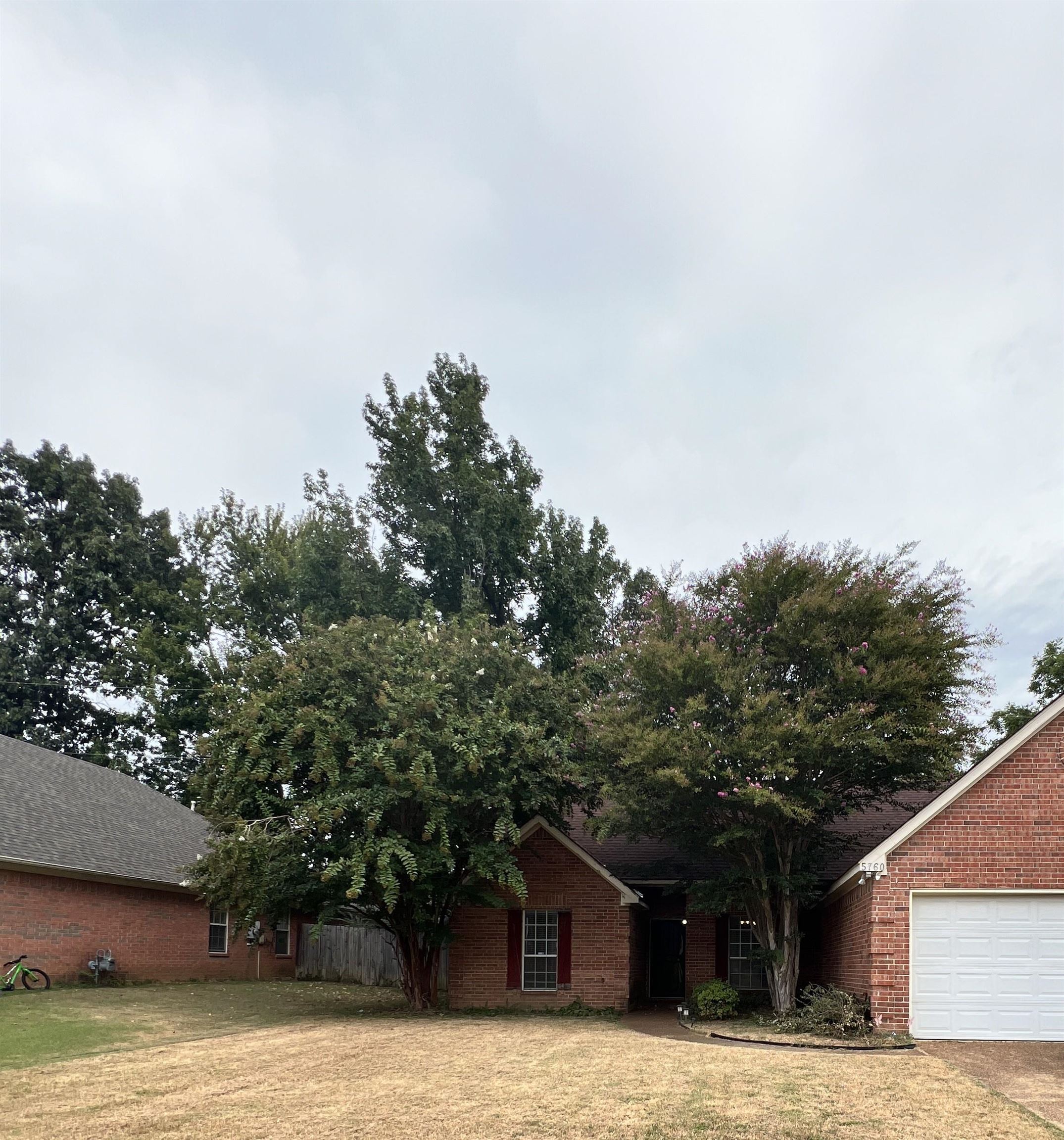 View of front facade with brick siding and a garage