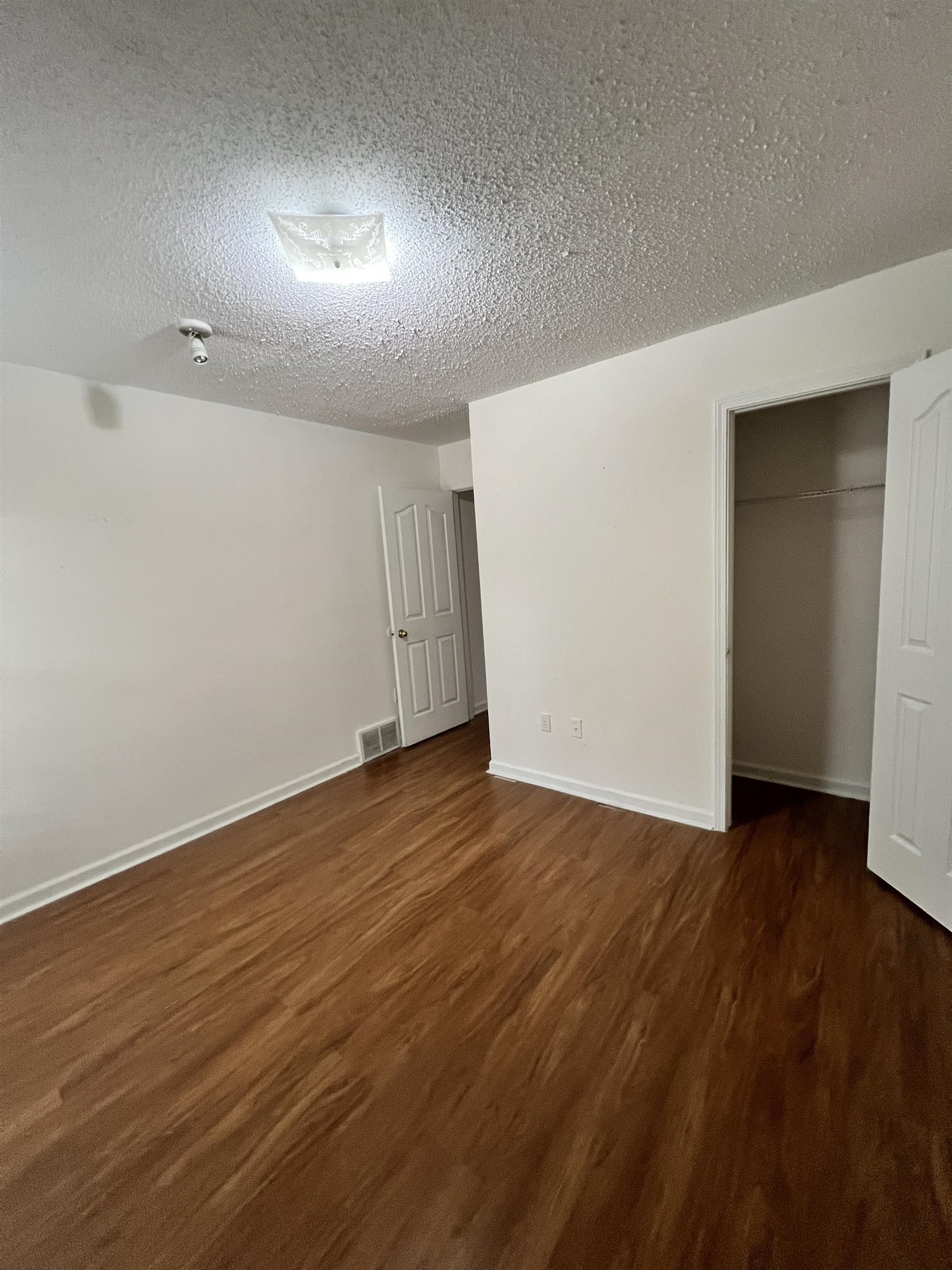 5760 Pecan Trace Memphis, TN 38135 - Photo 15 of 15 Unfurnished bedroom with a textured ceiling, dark wood-type flooring, and a closet