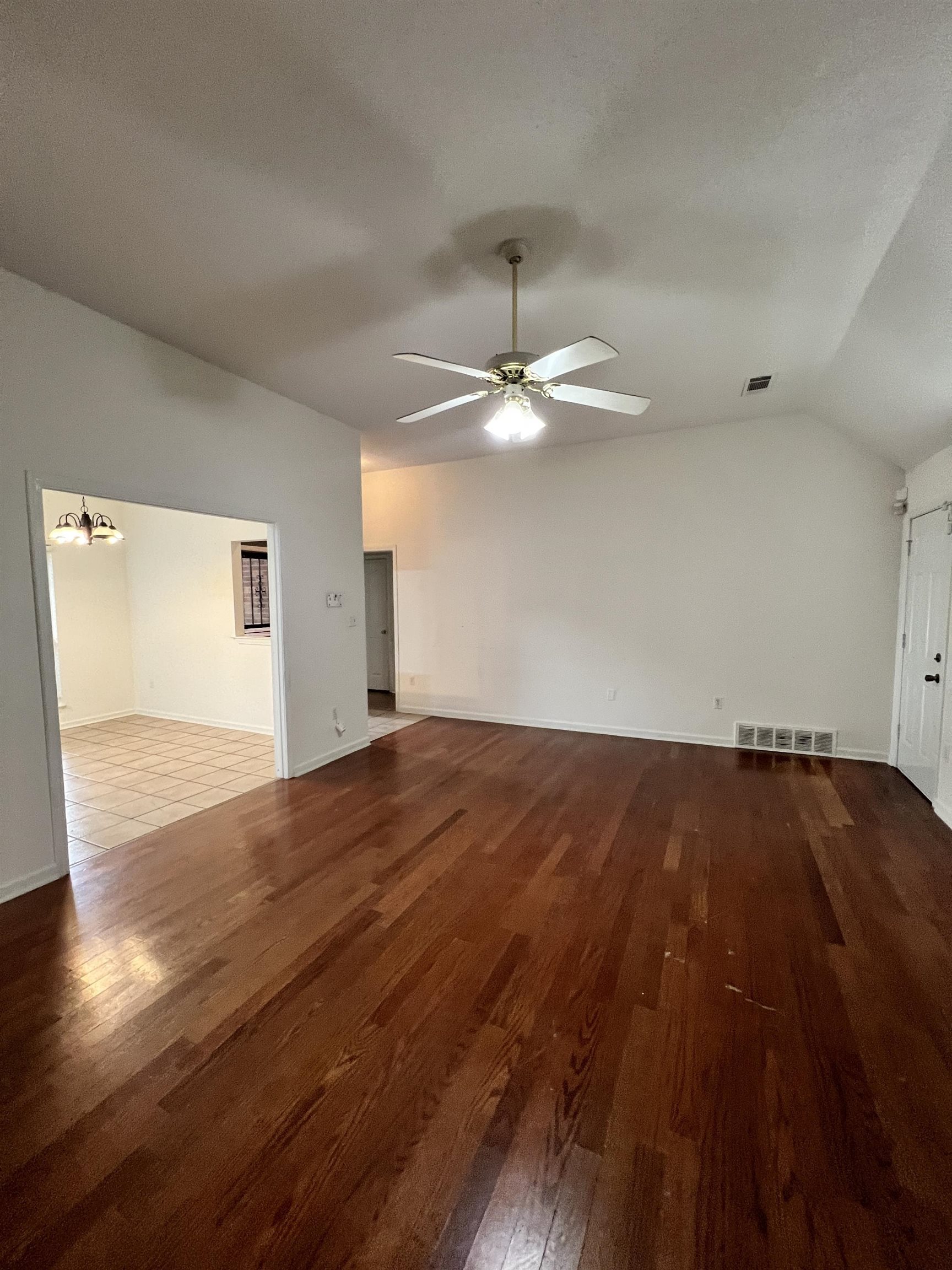 5760 Pecan Trace Memphis, TN 38135 - Photo 5 of 15 Unfurnished living room with dark wood-style flooring, lofted ceiling, a chandelier, and ceiling fan