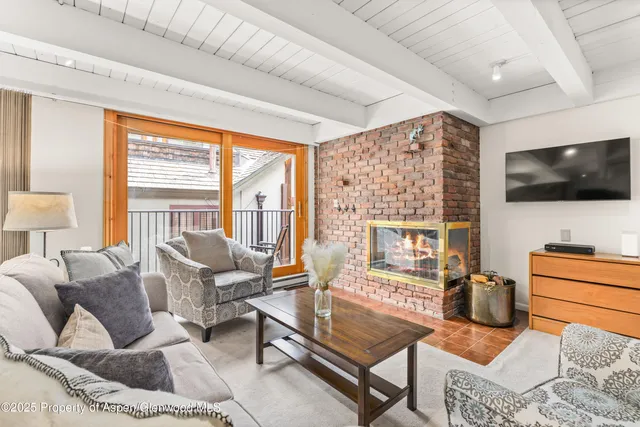 a living room with furniture a flat screen tv and a floor to ceiling window