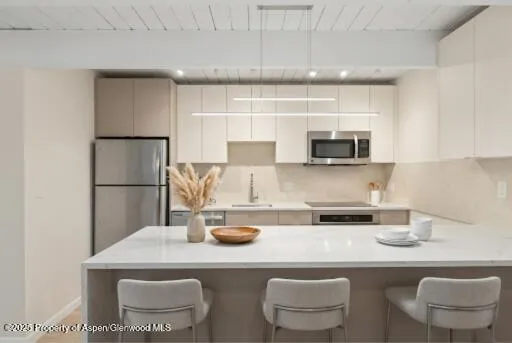 a kitchen with stainless steel appliances a dining table and chairs