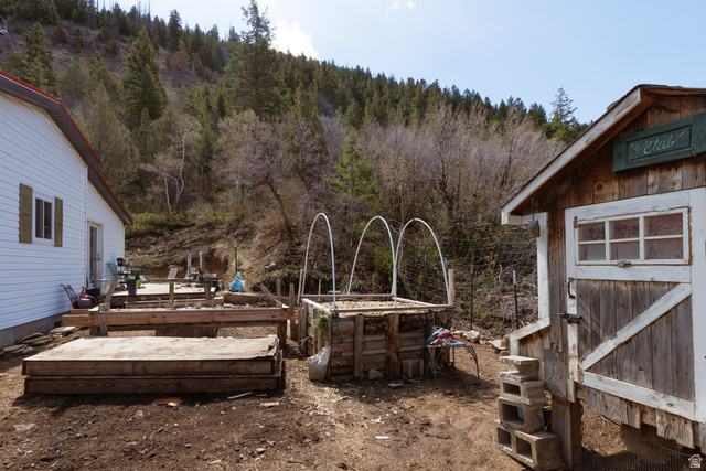 3902 Beaver Creek Road Kamas, UT 84036 - Photo 23 of 33 View of yard featuring a wooden deck, raised planter, chicken coop and a forest view