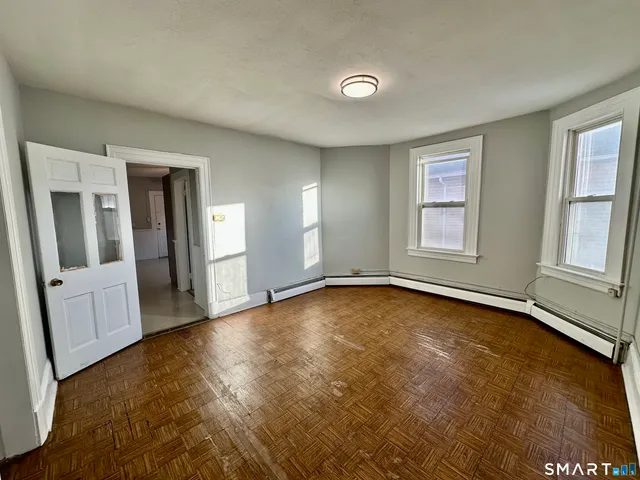 an empty room with window and wooden floor