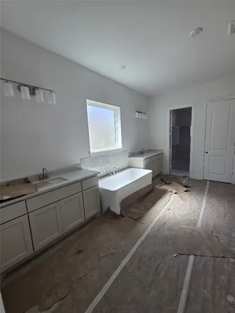 a spacious bathroom with a double vanity sink and a bathtub