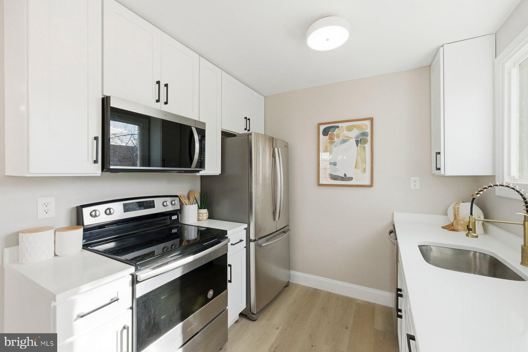 3802 Elby Court Silver Spring, MD 20906 - Photo 11 of 33 a kitchen with stainless steel appliances a stove microwave and sink