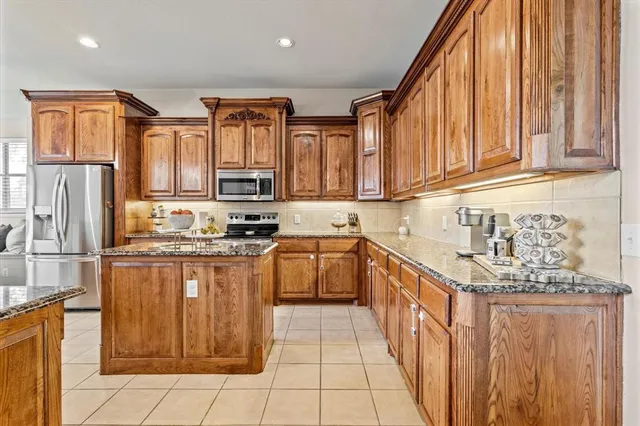 a kitchen with stainless steel appliances granite countertop a stove a sink dishwasher and a refrigerator