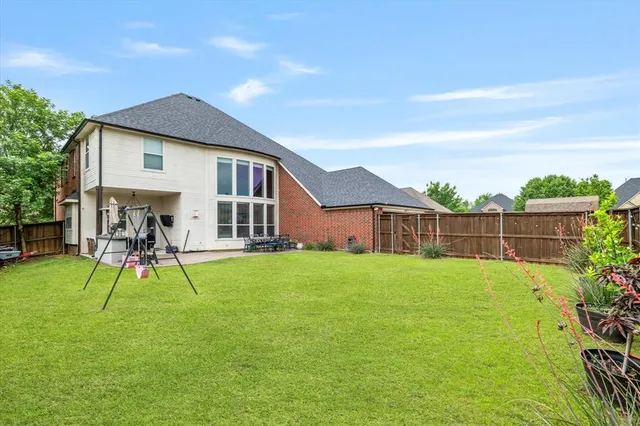 a view of backyard of house with a patio