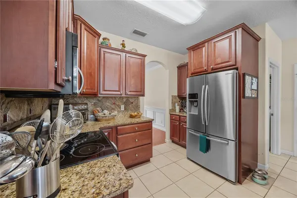 a kitchen with stainless steel appliances granite countertop a refrigerator stove and sink