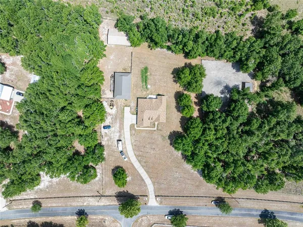 an aerial view of a house with a yard and large trees